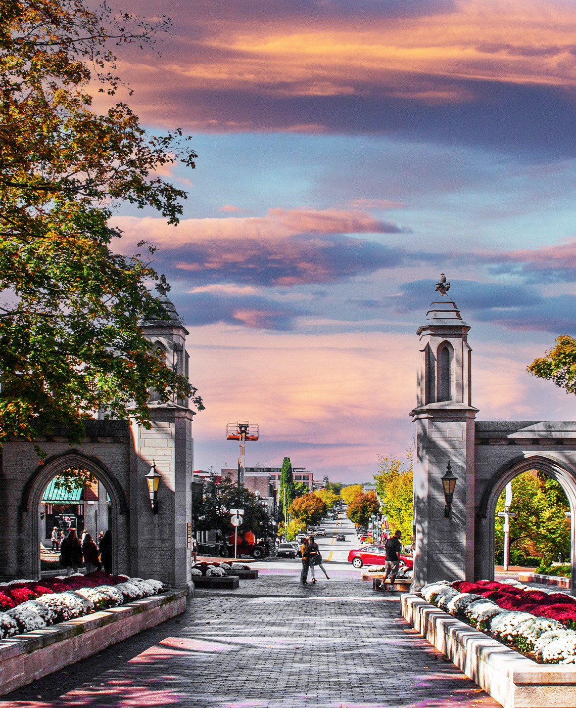 Indiana University sample gates at sunset with flowers and a view of the main street