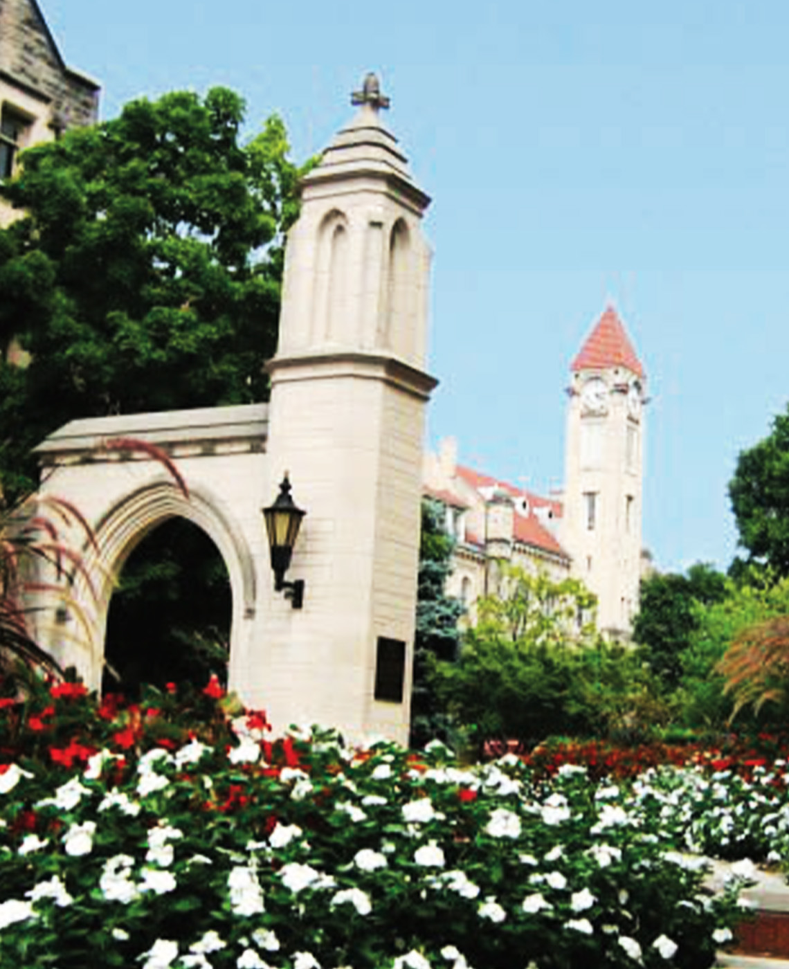 Indiana University sample gates during day time with a bed of white and red flowers in front