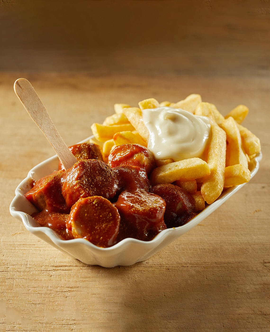 Currywurst and fries on a wooden table